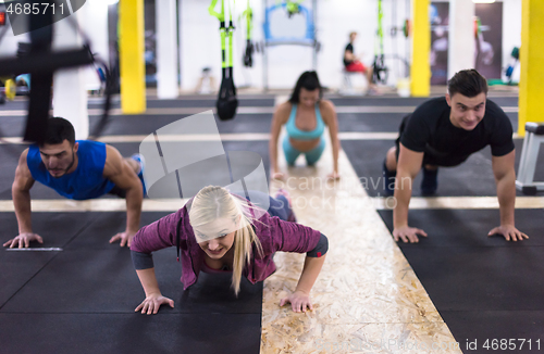 Image of young healthy people doing pushups