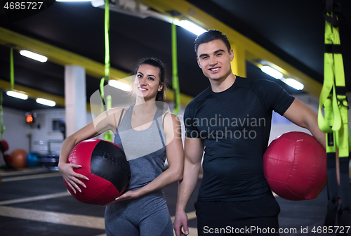 Image of young athletes couple working out with medical ball