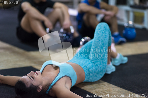 Image of young athlete woman lying on the floor and relaxing