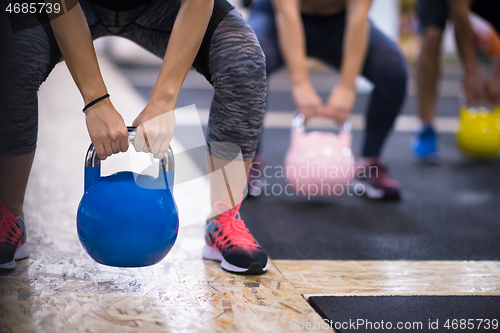 Image of athletes doing exercises with kettlebells