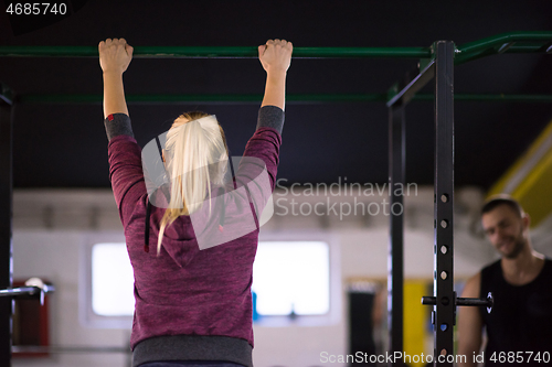 Image of woman doing pull ups on the horizontal bar