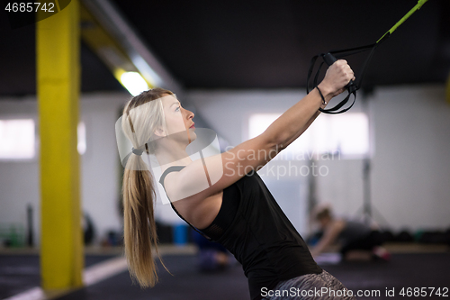 Image of woman working out pull ups with gymnastic rings