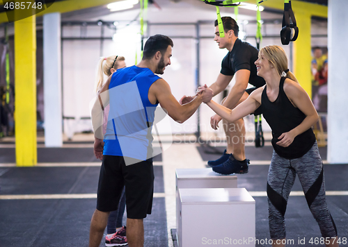 Image of athletes working out  jumping on fit box