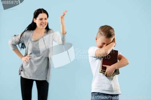 Image of Angry mother scolding her son in living room at home