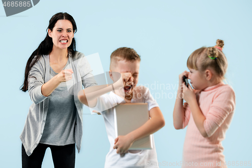 Image of Angry mother scolding her son in living room at home