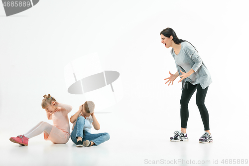 Image of Angry mother scolding her son in living room at home