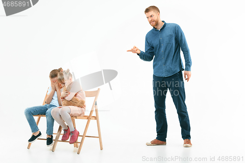 Image of Angry father scolding his son in living room at home