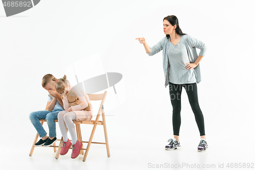 Image of Angry mother scolding her son in living room at home