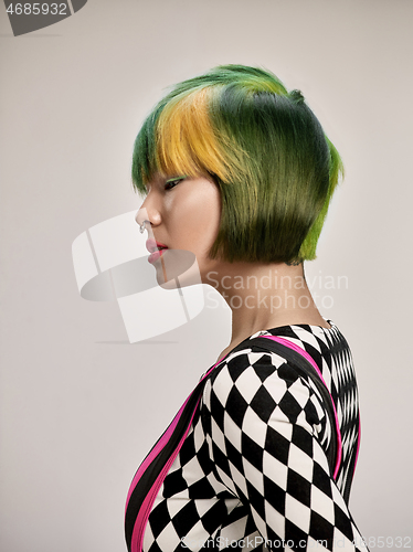 Image of Close-up indoor portrait of lovely girl with colorful hair. Studio shot of graceful young woman with short haircut