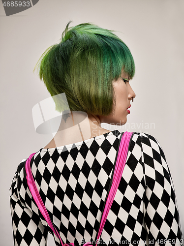 Image of Close-up indoor portrait of lovely girl with colorful hair. Studio shot of graceful young woman with short haircut