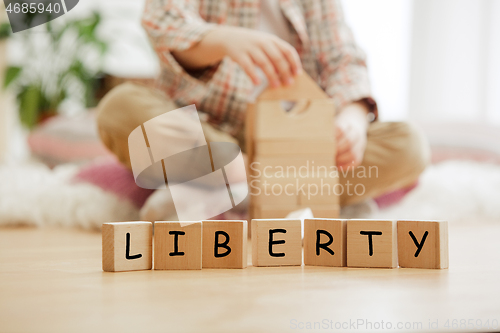 Image of Wooden cubes with word LIBERTY in hands of little boy