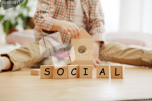 Image of Wooden cubes with word SOCIAL in hands of little boy