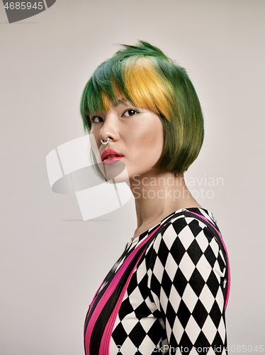 Image of Close-up indoor portrait of lovely girl with colorful hair. Studio shot of graceful young woman with short haircut