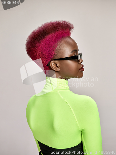 Image of Close-up indoor portrait of lovely girl with colorful hair. Studio shot of graceful young woman with long haircut