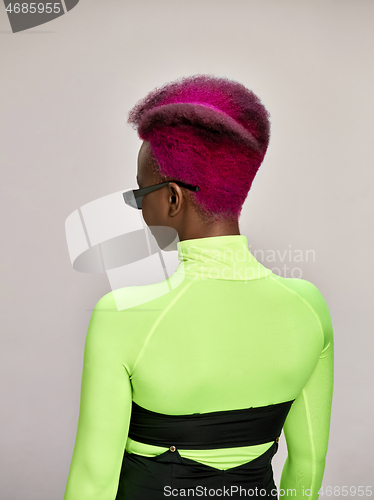 Image of Close-up indoor portrait of lovely girl with colorful hair. Studio shot of graceful young woman with long haircut