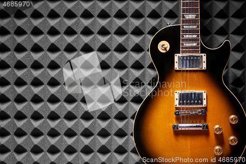 Image of Sunburst electric guitar on acoustic foam panel