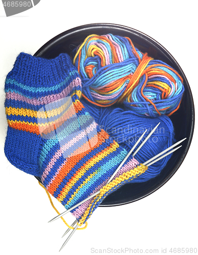 Image of wool knitted sock, yarn and knitting needles on white