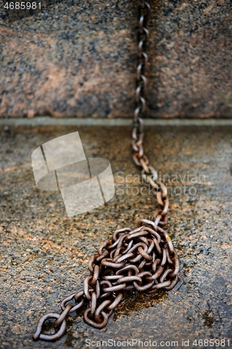 Image of old rusty cast iron chain on granite 