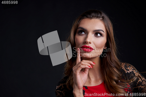 Image of Closeup woman in red dress and red lips makeup looking away
