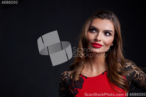 Image of Closeup woman in red dress and red lips makeup looking away