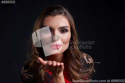 Image of Closeup woman red lips makeup blowing a kiss at camera