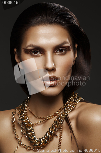 Image of beautiful girl with many golden and bronze chains