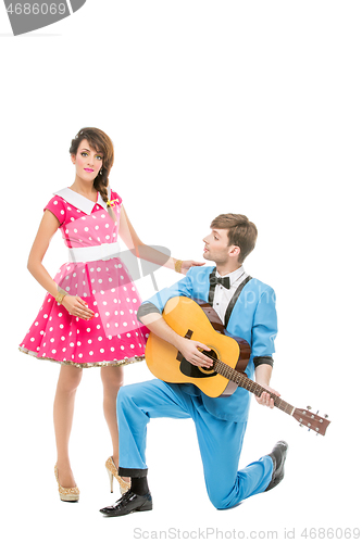 Image of doll looking boy and girl with guitar