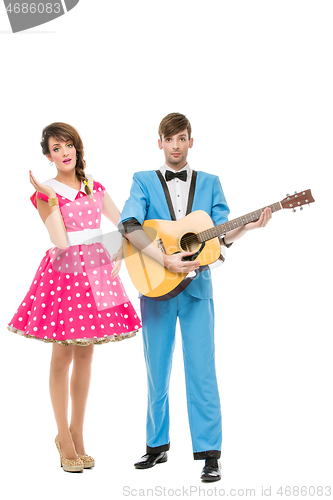 Image of doll looking boy and girl with guitar