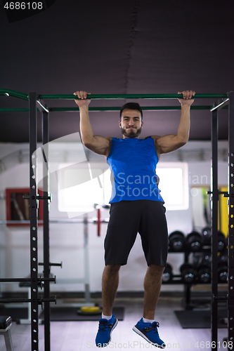 Image of man doing pull ups on the horizontal bar