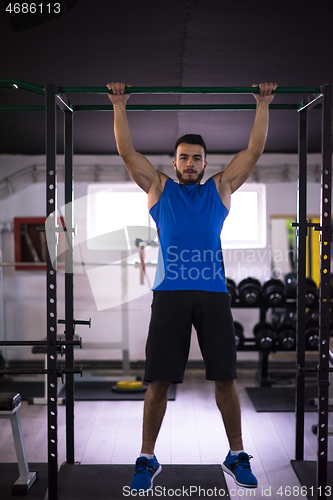 Image of man doing pull ups on the horizontal bar