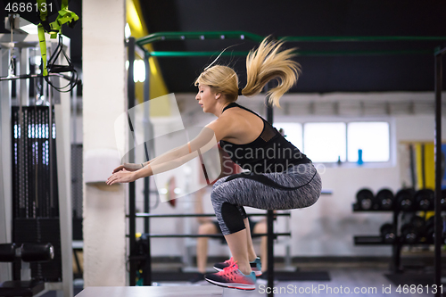 Image of woman working out  jumping on fit box