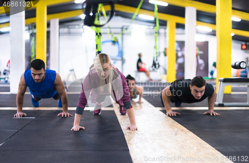 Image of young healthy people doing pushups