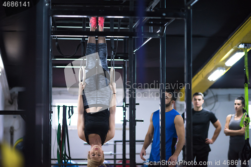 Image of woman working out with personal trainer on gymnastic rings