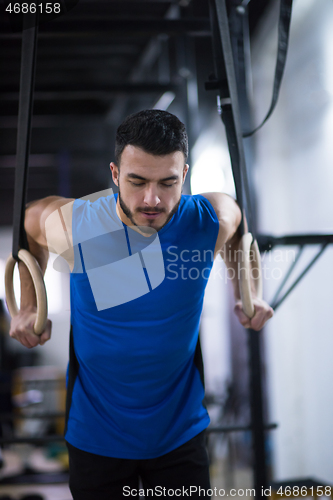 Image of man working out pull ups with gymnastic rings