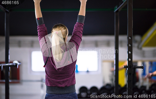 Image of woman doing pull ups on the horizontal bar