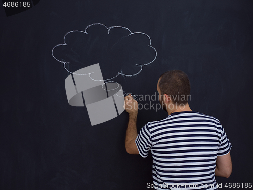 Image of young future father thinking in front of black chalkboard