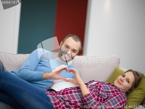 Image of man and pregnant woman showing heart sign