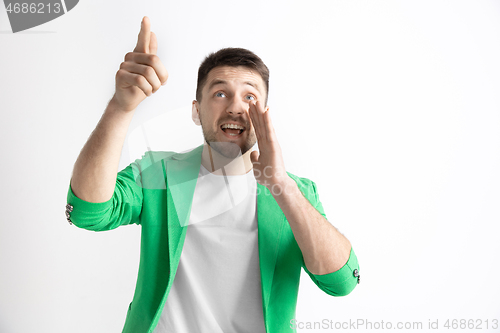 Image of The happy businessman standing and smiling against gray background.