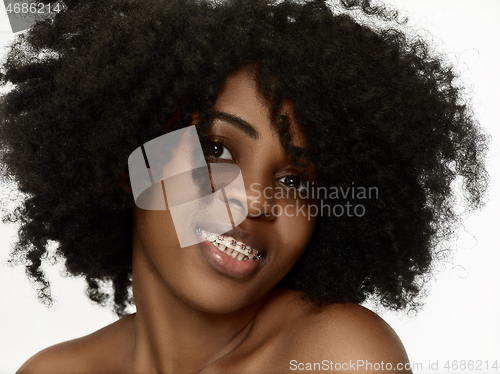 Image of Portrait of a young black woman smiling with braces