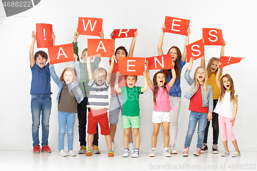 Image of Awareness. Group of children with a red banners isolated in white