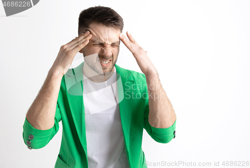Image of Man having headache. Isolated over gray background.