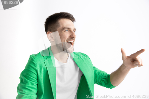 Image of The happy businessman standing and smiling against gray background.