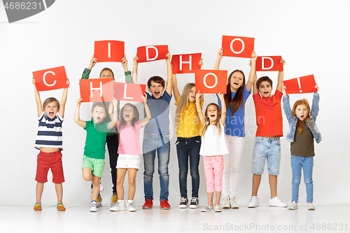 Image of Childhood. Group of children with a red banners isolated in white