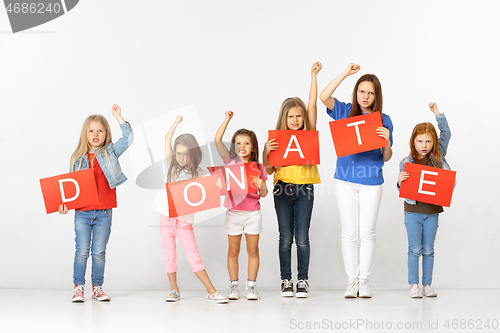 Image of Donate. Group of children with red banners isolated in white