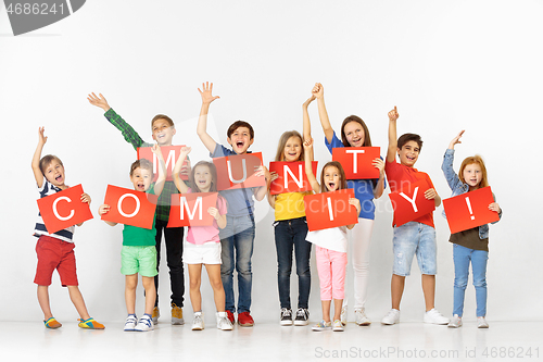 Image of Community. Group of children with a red banners isolated in white