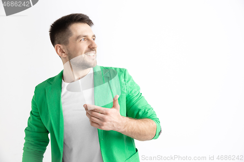 Image of The happy businessman standing and smiling against gray background.