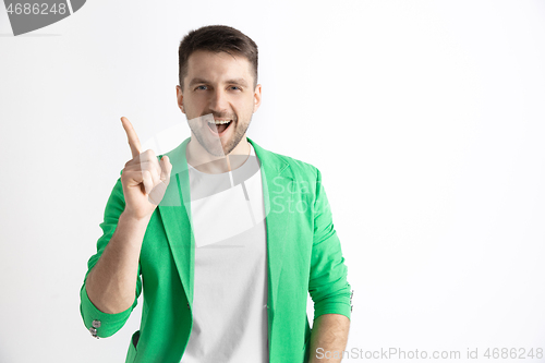 Image of The happy businessman standing and smiling against gray background.