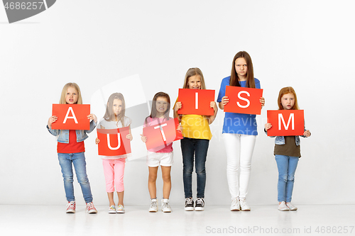 Image of Autism. Group of children with red banners isolated in white