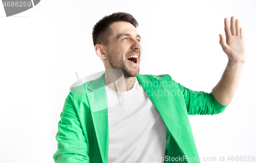 Image of The happy businessman standing and smiling against gray background.