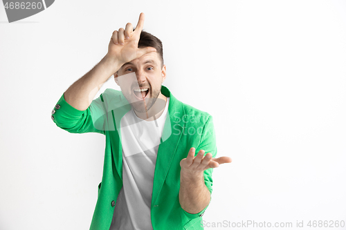 Image of Losers go home. Portrait of happy guy showing loser sign over forehead